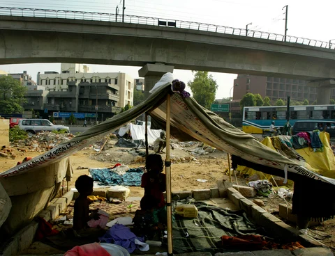 Children sit in their tents pitched in the middle of a busy road in New Delhi, India (Photographer: Amit Bhargava/Bloomberg News.) 