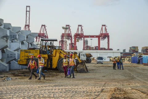 Workers walk past excavators at the site of Colombo Port City, developed by China Harbour Engineering Co. (Photographer: Atul Loke/Bloomberg)