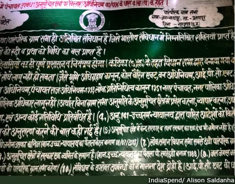 Sections of the Constitution, the Forest Rights Act and the Panchayat Extension to Scheduled Areas Act, painted on a green board and erected near villages in Surajpur district, northern Chhattisgarh. Villagers are yet to receive individual or community forest rights.