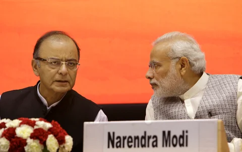 Finance Minister Arun Jaitley speaks to Prime Minister Narendra Modi, at the launch of the MUDRA Yojana, in New Delhi. (Photographer: Kuni Takahashi/Bloomberg)