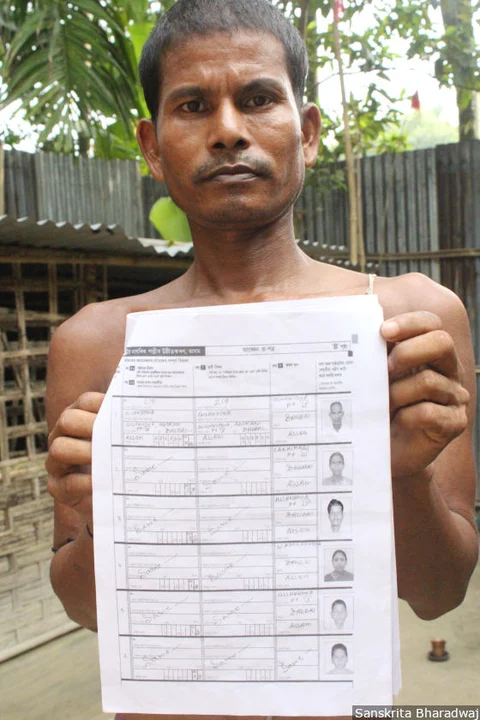 Mahendra Barman holds up his family’s NRC application form.