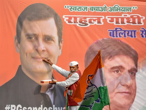 A Congress supporter offers sweets to a photo of Rahul Gandhi, in Lucknow, on Dec. 11, 2018. (Photographer: Nand Kumar/PTI)