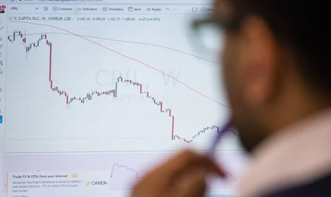 A trader monitors financial data. (Photographer: Chris Ratcliffe/Bloomberg)