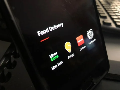 Application icons of UberEats, Swiggy, Zomato and Foodpanda are visible on a phone. (Source: BloombergQuint)