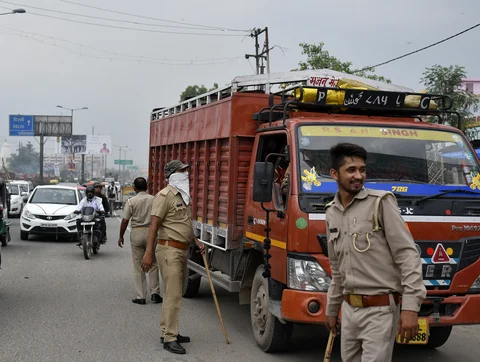 Police officers check commercial vehicles for customs purposes at the Bhopura checkpoint at the Delhi-Uttar Pradesh border in Ghaziabad, Uttar Pradesh, India. Photographer: Anindito Mukherjee/Bloomberg
