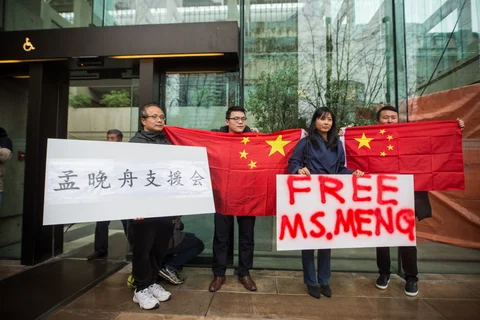 People hold signs and Chinese flags in support Meng Wanzhou, chief financial officer of Huawei Technologies, outside of a bail hearing at the Supreme Court in Vancouver, Canada, on Dec. 11, 2018. (Photographer: James MacDonald/Bloomberg)