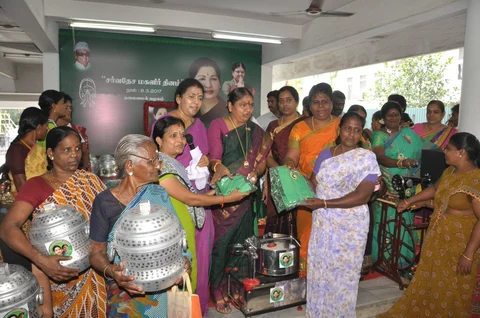 AIADMK party workers hand out cookers, grain mixers, sarees, and sewing machines. (Photograph: Twitter/@AIADMKOfficial)
