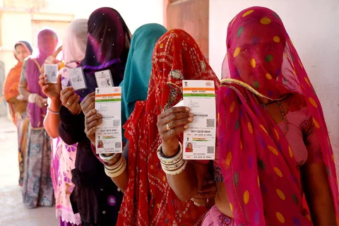 Women in Rajasthani show their Aadhaar cards while standing in a queue. (Photograph: PTI)