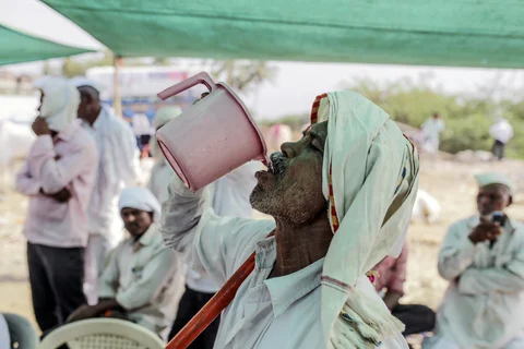 A man drinks water at a cattle market in Beed, Maharashtra, India. (Photographer: Dhiraj Singh/Bloomberg)