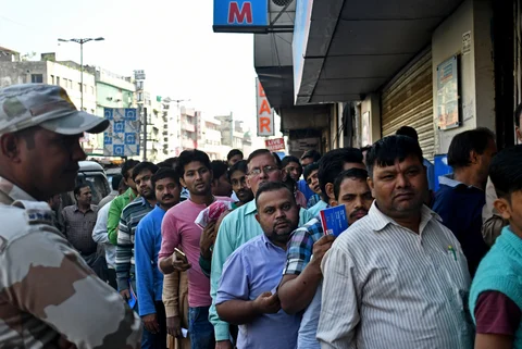 People wait in line outside a bank branch in Delhi on Nov. 25, 2016. (Photographer: Anindito Mukherjee/Bloomberg)
