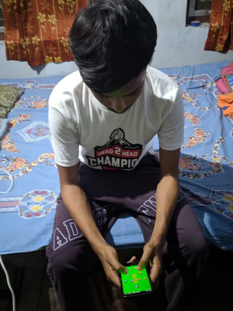 Vasisth Roy playing on his phone.