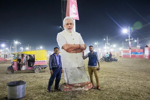Pilgrims with a cutout of Modi. (Photographer: Anshika Varma for Bloomberg Businessweek)