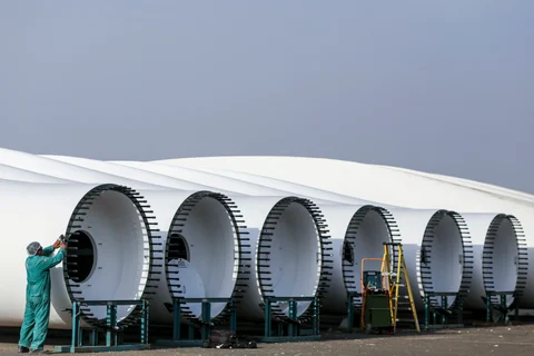An employee works on a turbine blade at the Suzlon Energy rotor blade manufacturing plant in Bhuj, Gujarat. (Photographer: Dhiraj Singh/Bloomberg)