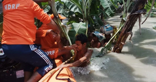 NDRF personnel rescue the residents using boats from the flood-affected area of Morigaon