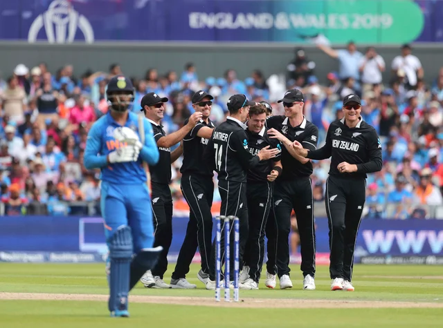New Zealand's Matt Henry, center without cap, celebrates with teammates the dismissal of India's K.L. Rahul, left, during the Cricket World Cup semi-final match between India and New Zealand