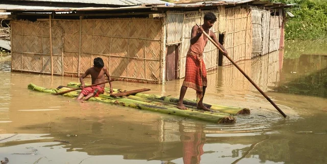People using Banana raft move to a safer place on a boat from a flood-affected area, at Panikhaiti in Kamrup district of Assam