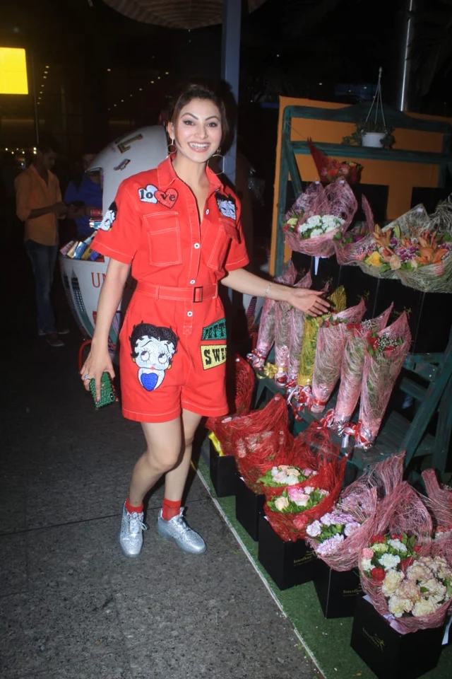 Urvashi Rautela was snapped at the Mumbai airport in a Red romper and paired it with silver sneakers.