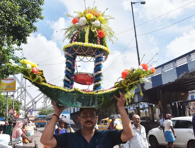 A devotee carrying puja materials from a market on the occasion of the Janmashtami Puja festival in Kolkata