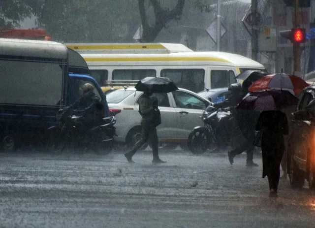 Pedestrians trying to cross an intersection during incessant rain at the Elphinstone area in Mumbai