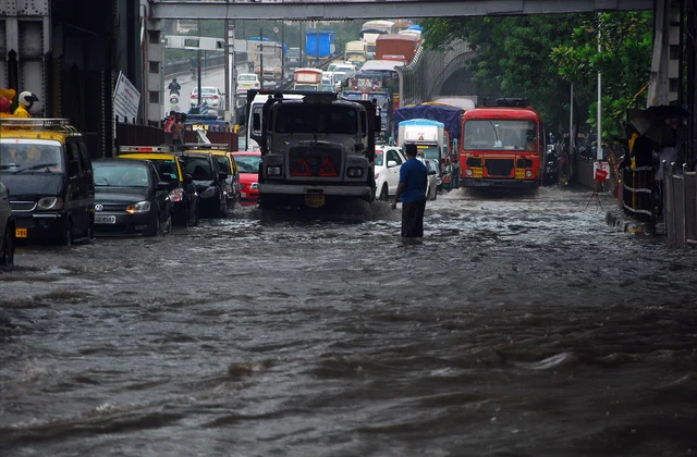 Vehicles pass on the waterlogged road after heavy rain at King Circle