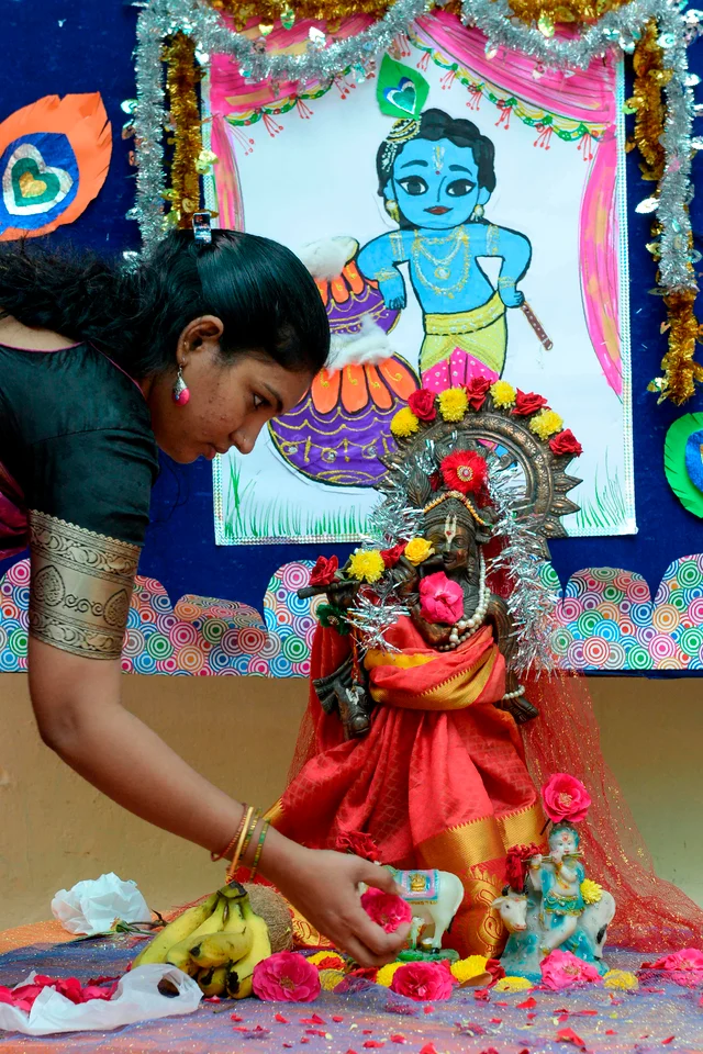 A teacher decorates the statue of Hindu god Lord Krishna ahead of celebrations on the occasion of Janamashtami, the birthday of Lord Krishna, in Hyderabad