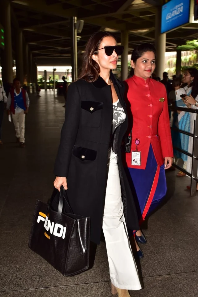 Malaika was spotted with a Fendi bag and a full length jacket with a white bell bottoms and a white t-shirt.