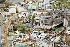 A man (C) walks among debris of destroyed houses in the aftermath of<br />Super Typhoon Haiyan in Tacloban, eastern island of Leyte