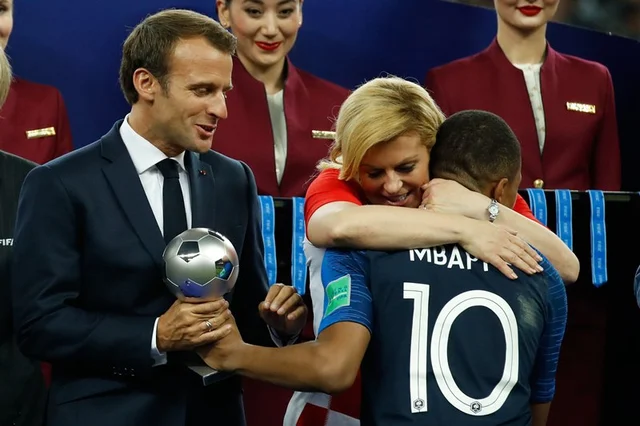 TOPSHOT – France’s forward Kylian Mbappe receives the silver ball for best young player from French President Emmanuel Macron and Croatian President Kolinda Grabar-Kitarovic during the medals ceremony after the Russia 2018 World Cup final football match between France and Croatia at the Luzhniki Stadium in Moscow on July 15, 2018.