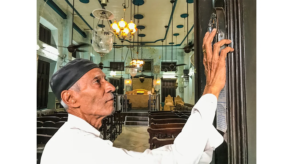 A Bene Israeli man kissing the <i>mezuzah</i> while entering the synagogue