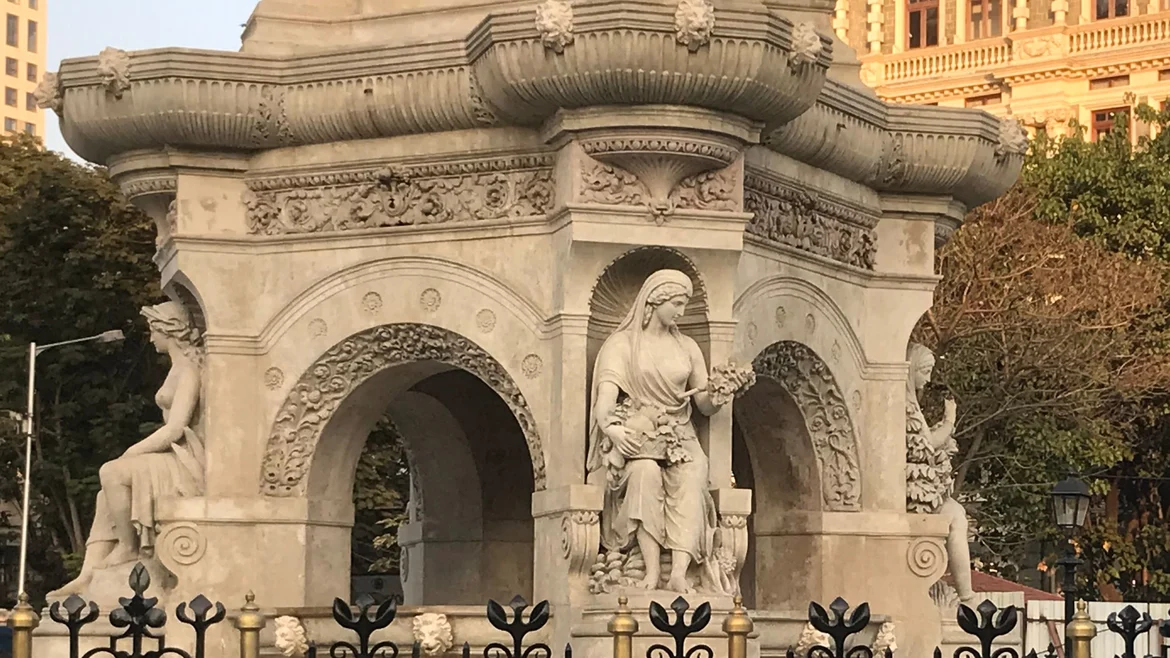 Female figures at the corners of the base