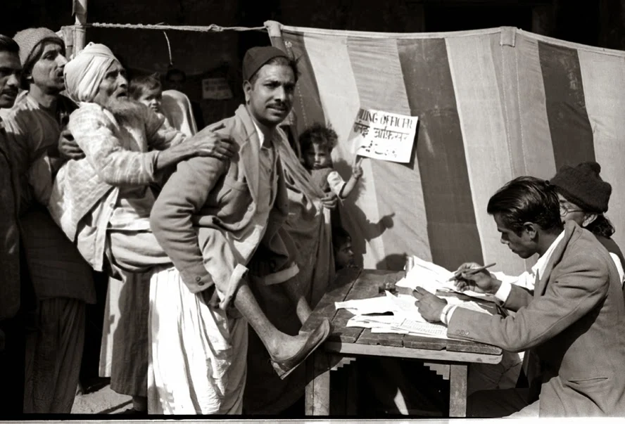 A blind old man being carried towards a polling booth to help him to cast his vote, Delhi