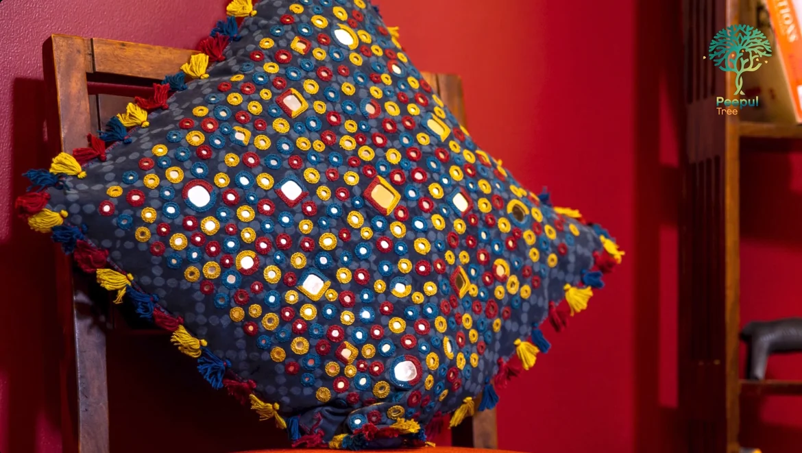 A cushion cover with Lambani embroidery and mirror work