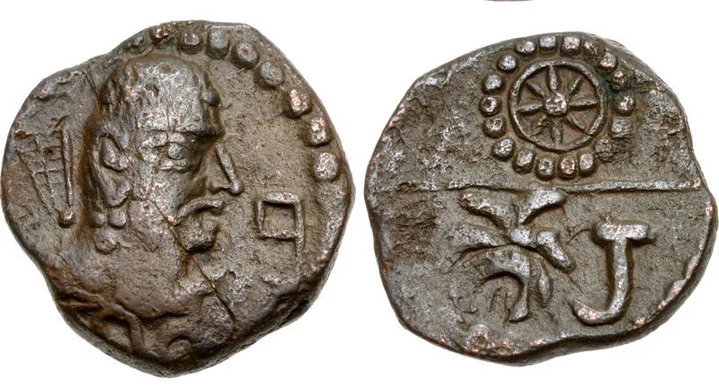 Coin of Toramana. The initials “Tora” in Brahmi script appear in large letters on the reverse, under the solar wheel design.