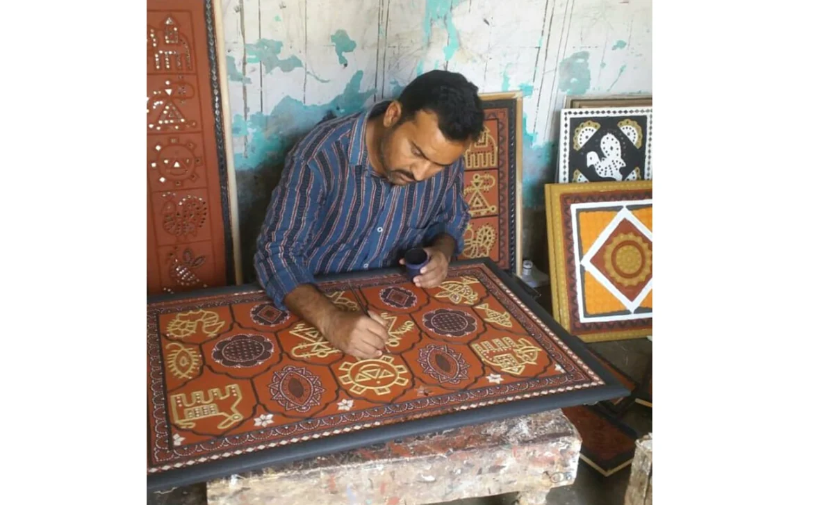 An artisan working on the Lippan art work