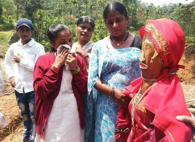 സംസ്കാരത്തിനായി ഒരുക്കിയ മരപ്പാവയ്ക്കൊപ്പം ബന്ധുക്കള് 