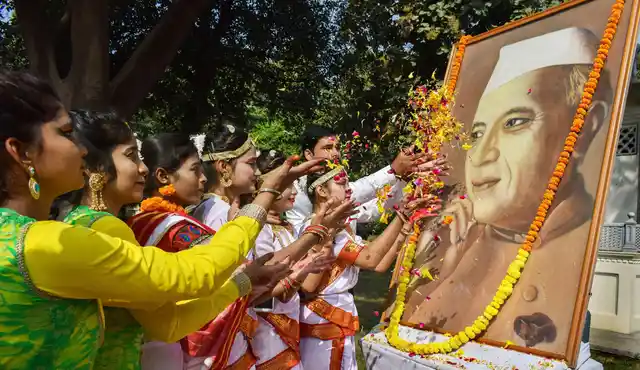 इलाहाबाद में पंडित जवाहर लाल नेहरू की 129वीं जयंती पर उनकी तस्वीर पर पुष्प अर्पित करते स्कूली बच्चे (फोटो- 14 नवंबर)