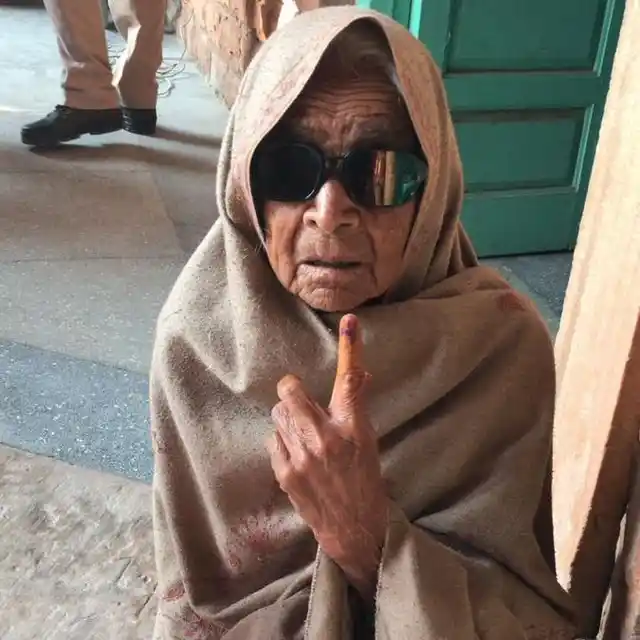 वोट डालने के बाद 80 साल की महिला स्याही का निशान दिखाती हुईं