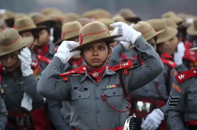 असम राइफल्स की भारतीय अर्धसैनिक महिला सैनिक अपनी टोपी ठीक करते हुए