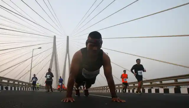 20 जनवरी को मुंबई मैराथन में हिस्सा लेने वाला एक शख्स बांद्रा-वर्ली सी लिंक पर पुशअप करते हुए, बाकी लोग दौड़ लगा रहे हैं.