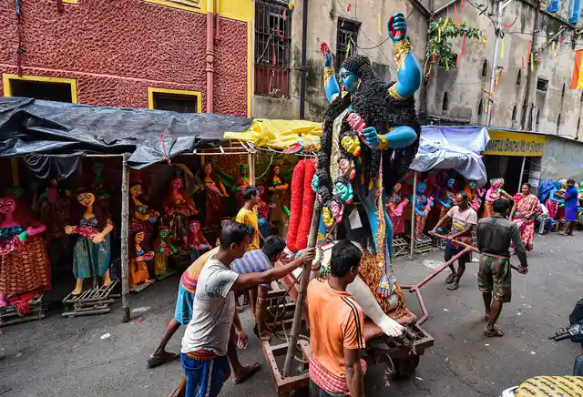 कोलकाता में काली पूजा की तैयारी, एक दिन पहले देवी काली की मूर्ति पूजा स्थल पर ले जाते भक्त
