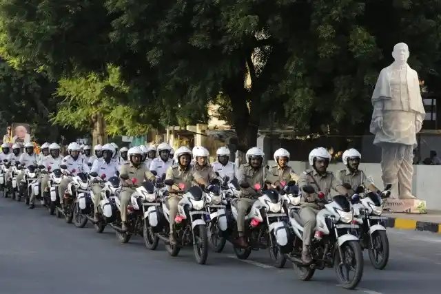 अहमदाबाद में सरदार पटेल के कटआउट के सामने से पुलिसकर्मी राइड पास्ट में हिस्सा लेते हुए (31 अक्टूबर)