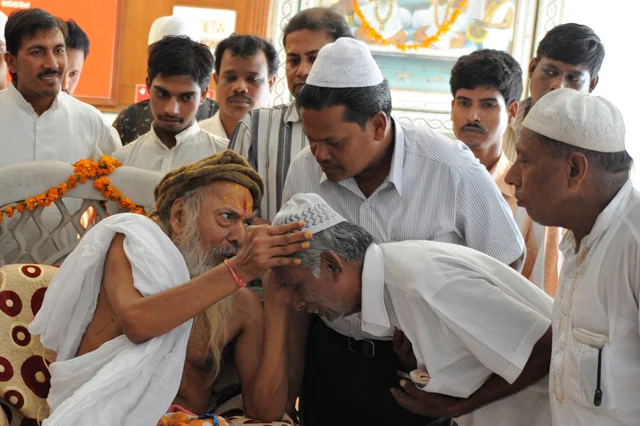 Hindu head priest of Lord Jagannath Mandir Mahant Shree Rameshwardasji Maharaj (L, front) blesses Muslims during a multi-religious event (Photo credit: SAM PANTHAKY/AFP/Getty Images)