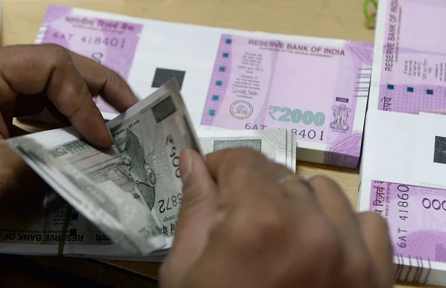 A bank staff member counts Rs 500 notes to give to customers. (INDRANIL MUKHERJEE/AFP/Getty Images)