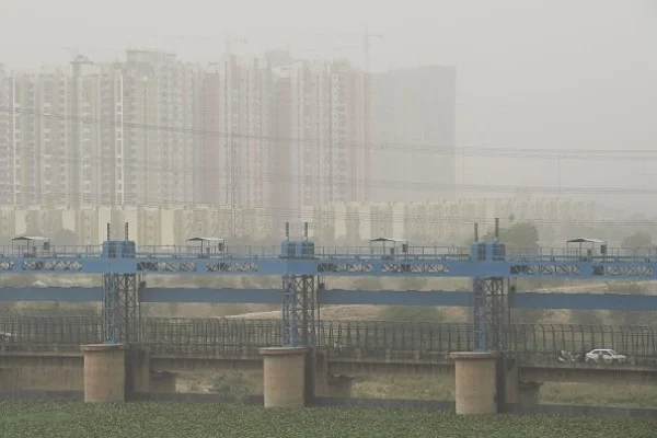 Vehicles cross a barrage on Hindon River as dust covers the skyline in Ghaziabad. (Prakash Singh/AFP/Getty Images)