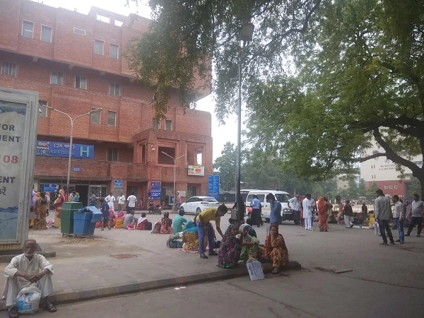 People wait to be attended to outside another government hospital in Delhi. 