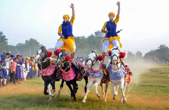 Men of the armed Sikh order Nihang show their horse-riding skills during a religious procession on ‘Fateh Divas’, or ‘Victory Day’, in Amritsar on Monday (28 October 2019). PTI
