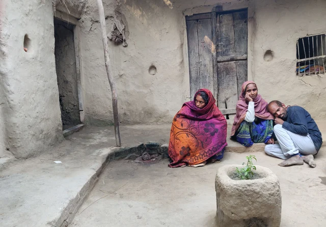 Inside her house,the victim’s brother is consoled by family and relatives