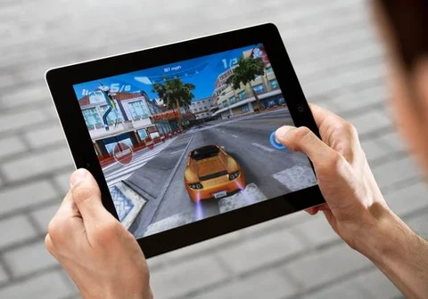 man playing racing game on iPad