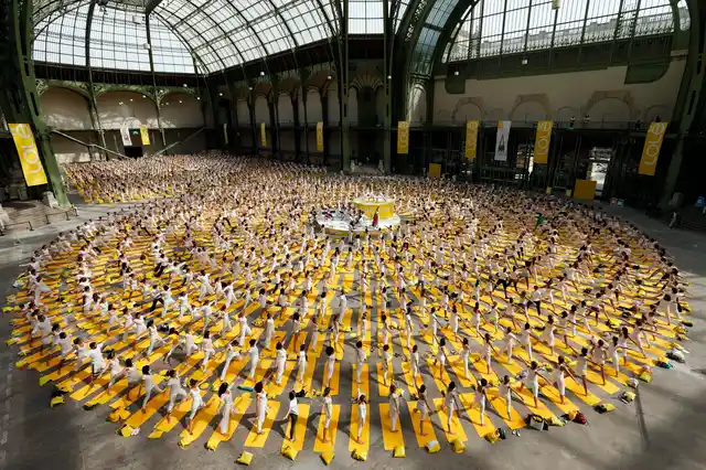 People take part in a group yoga practice at the Grand Palais in Paris. (Photo: Reuters)