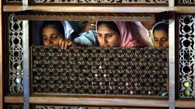 Women of the Dawoodi Bohra Muslim sect watch a wedding procession in Bombay. In India, the Dawoodi Bohra sect carries out female genital mutilation. (Photo: Reuters)